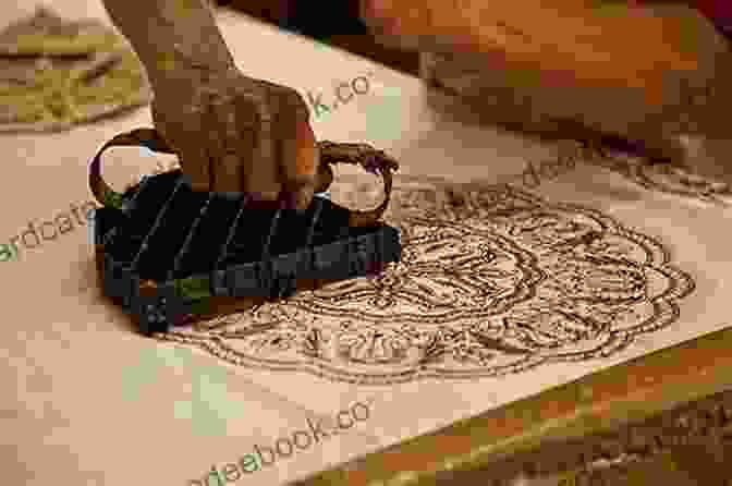 A Woman Using A Metal Stamp To Apply Wax To A Piece Of Fabric. BATIK FOR BEGINNERS: Guide To Types Of Batik Techniques And Lots More